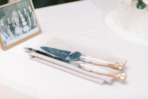 Wedding cake serving set placed on top of blush napkins.